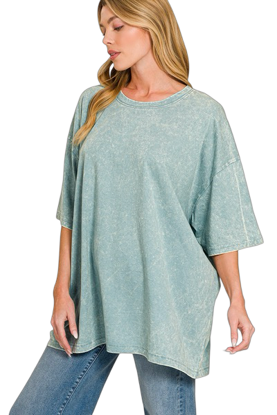 Woman wearing a light green oversized t-shirt and blue jeans on a white background