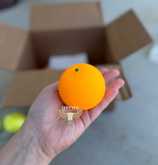 Orange ball held in a hand with a blurred background