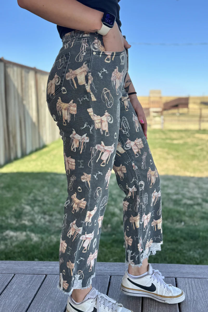 Person wearing patterned pants with animal design outdoors on a wooden deck.