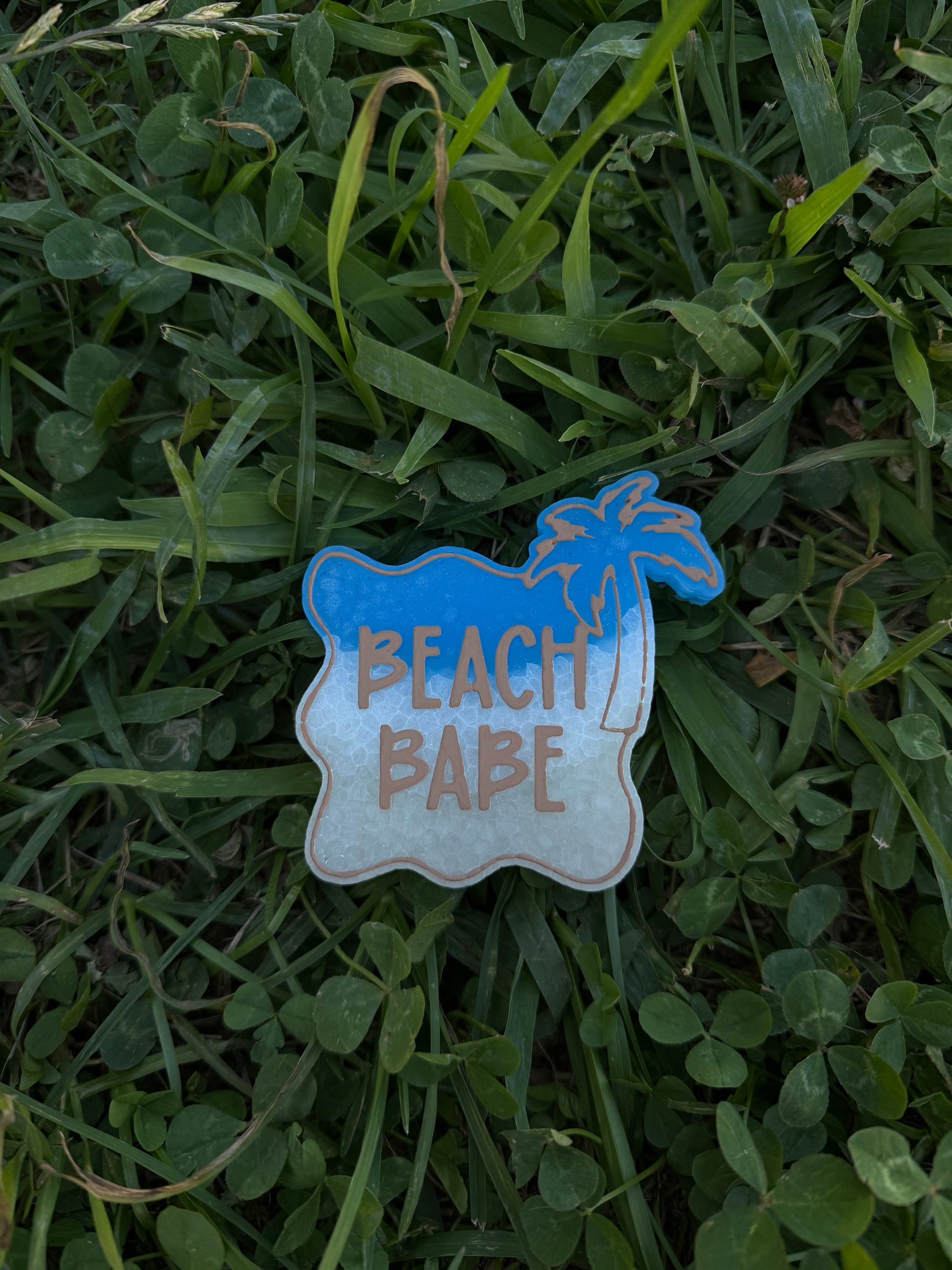 Freshie with 'Beach Babe' text on grass