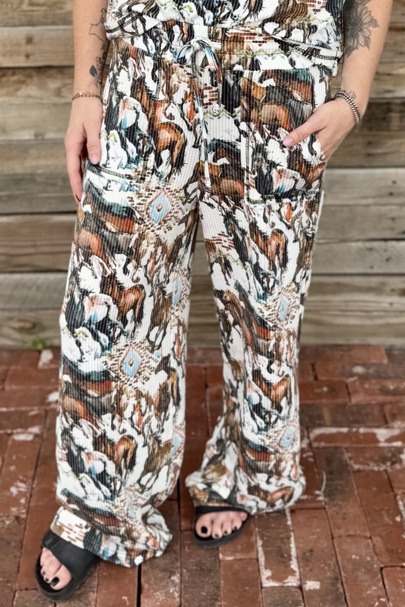 Person wearing a patterned outfit standing on a wooden floor.