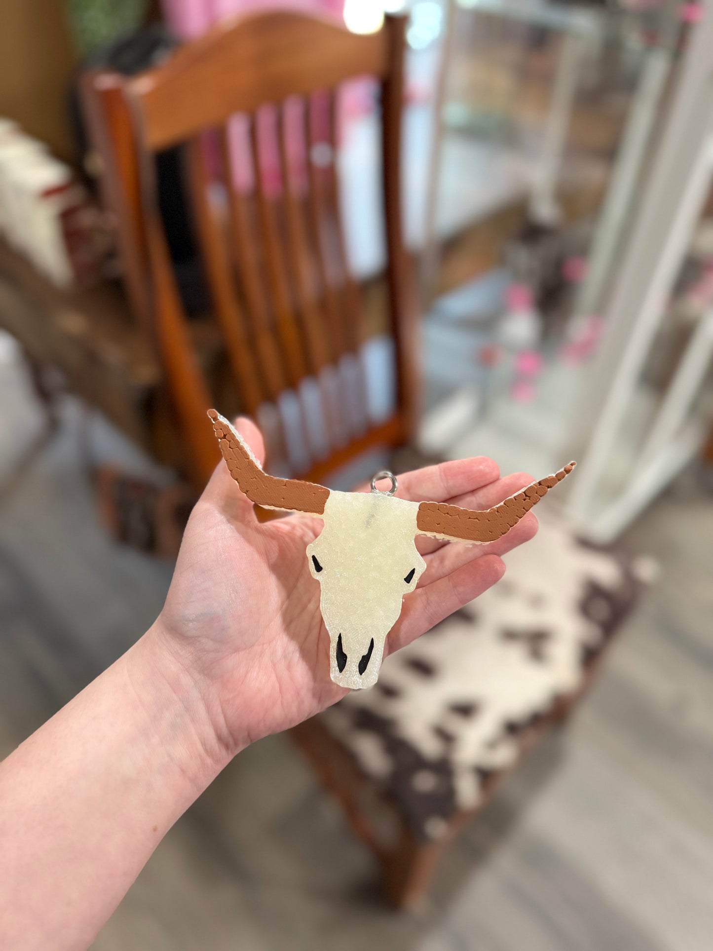 Hand holding a plain steer head car freshener 