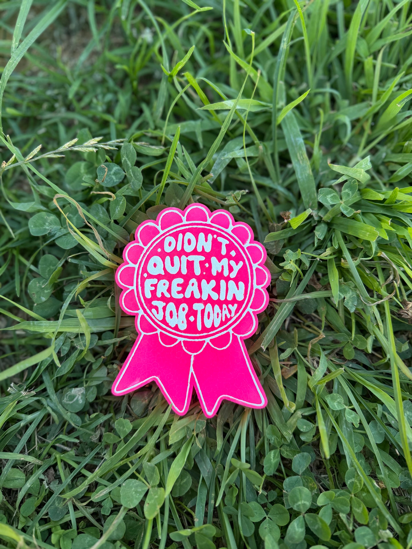 Pink badge freshie with text on grass