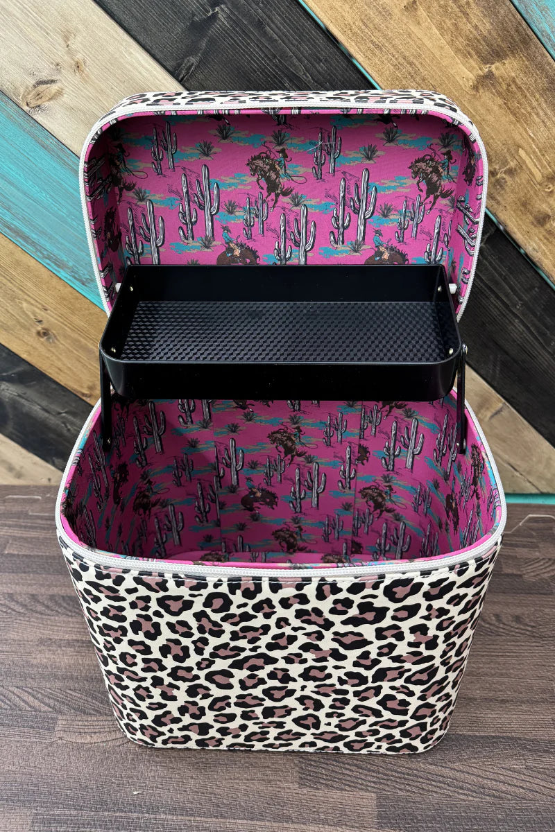 Makeup organizer with pink and black floral interior and leopard print exterior on a wooden surface.