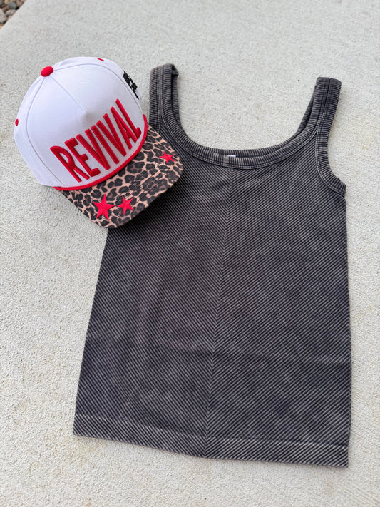 Gray tank top with a white cap and leopard print pouch on a light surface
