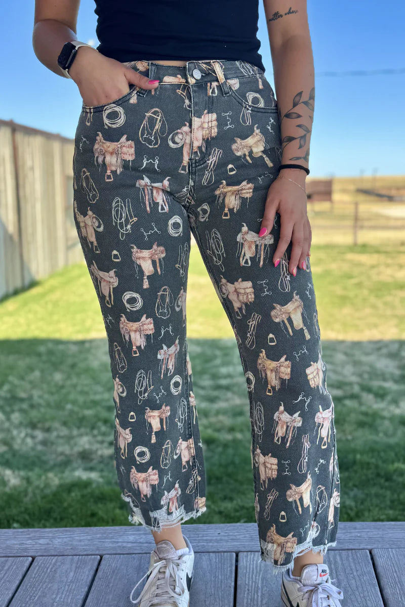Person wearing patterned pants with a cow design outdoors.
