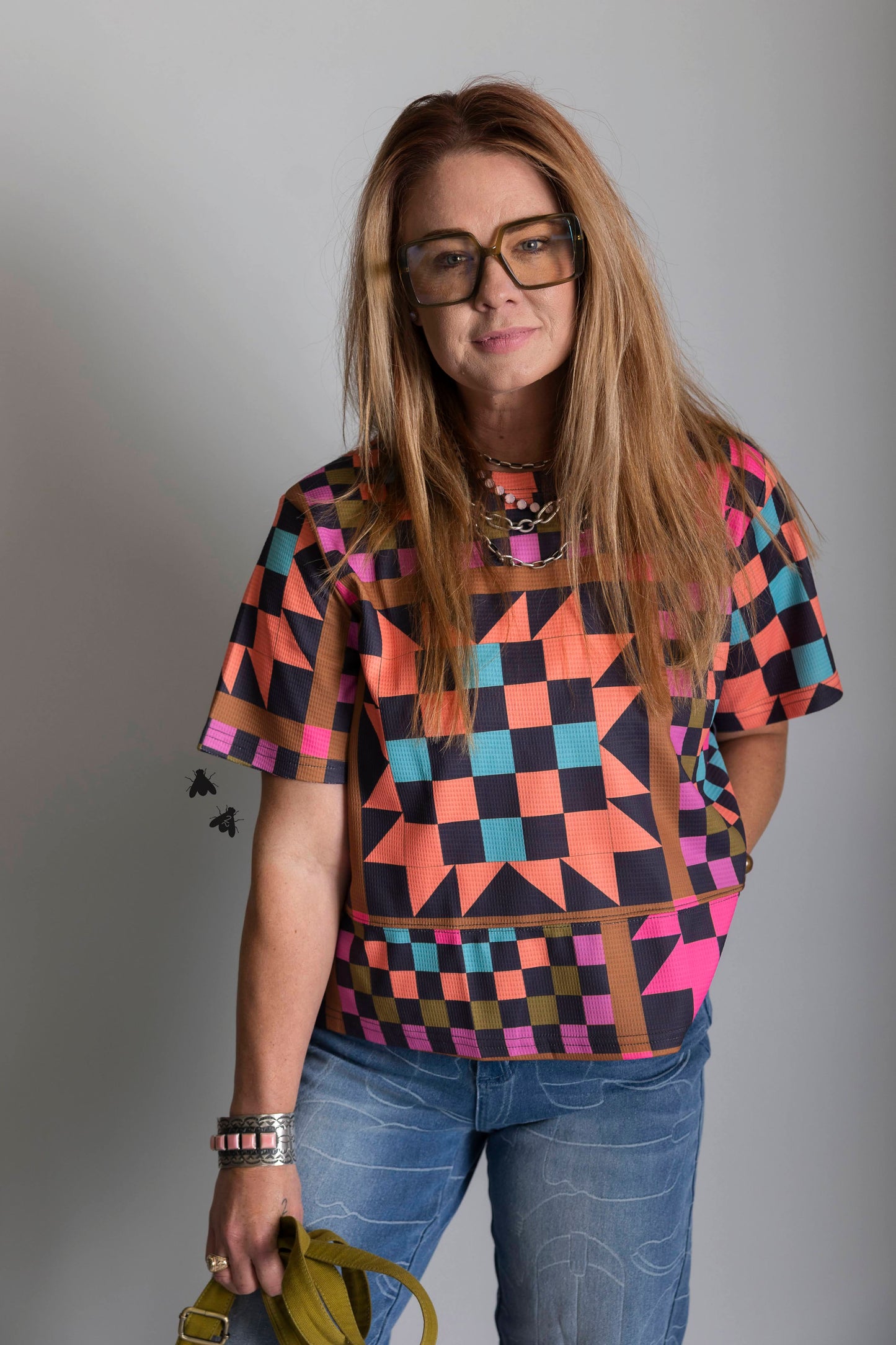 Person wearing a colorful geometric patterned shirt against a plain background