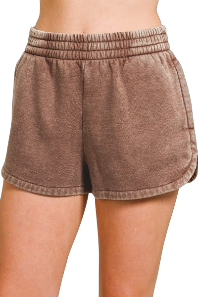 Brown shorts worn by a person on a white background