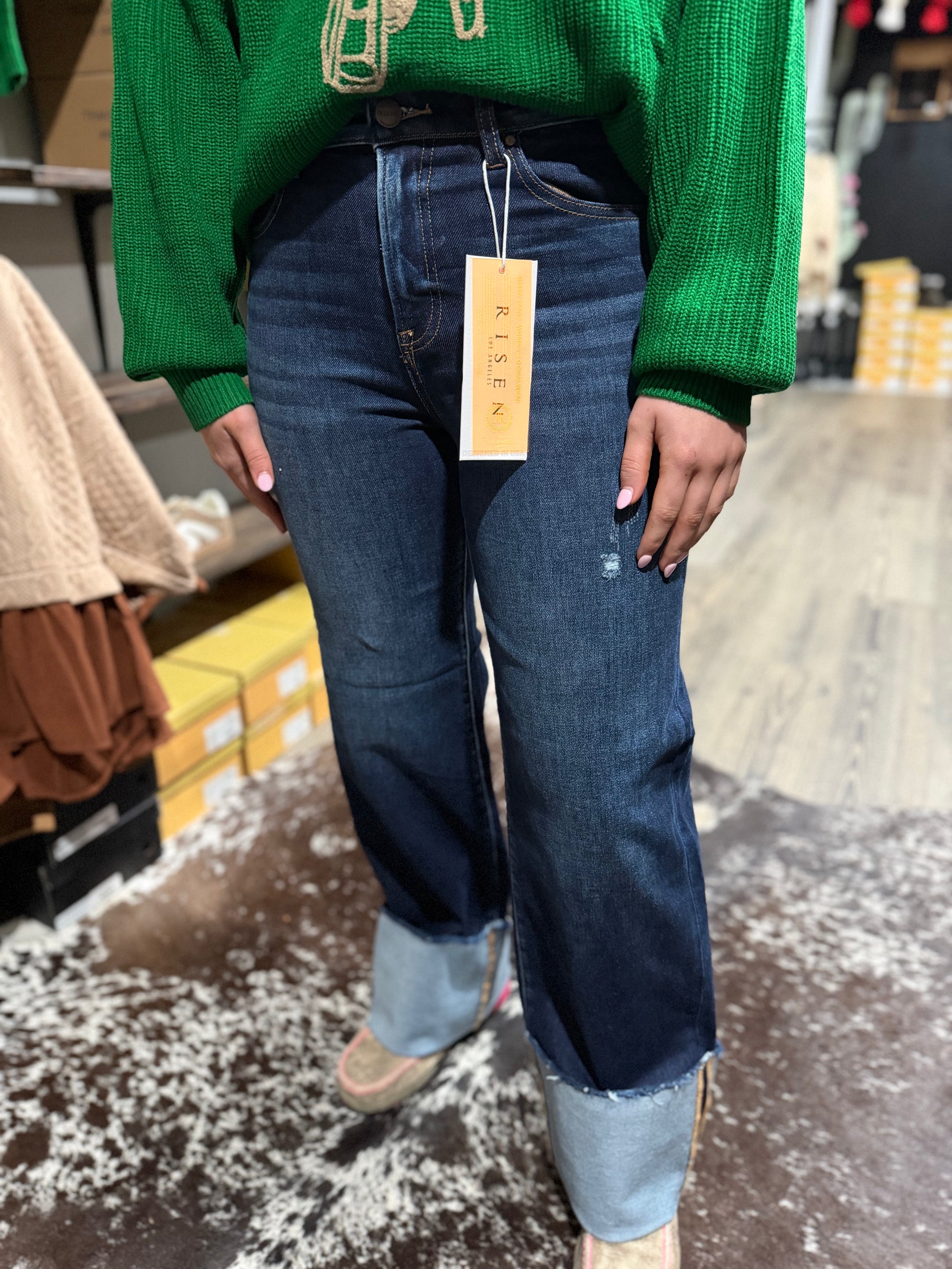 Person wearing blue jeans with a visible brand tag in an indoor setting