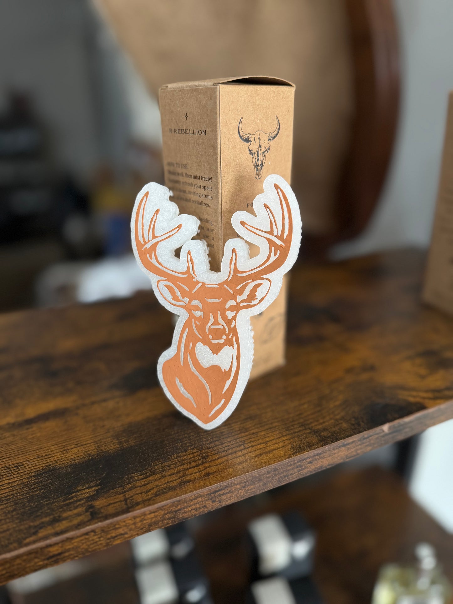 Cardboard box with deer head design on a wooden surface