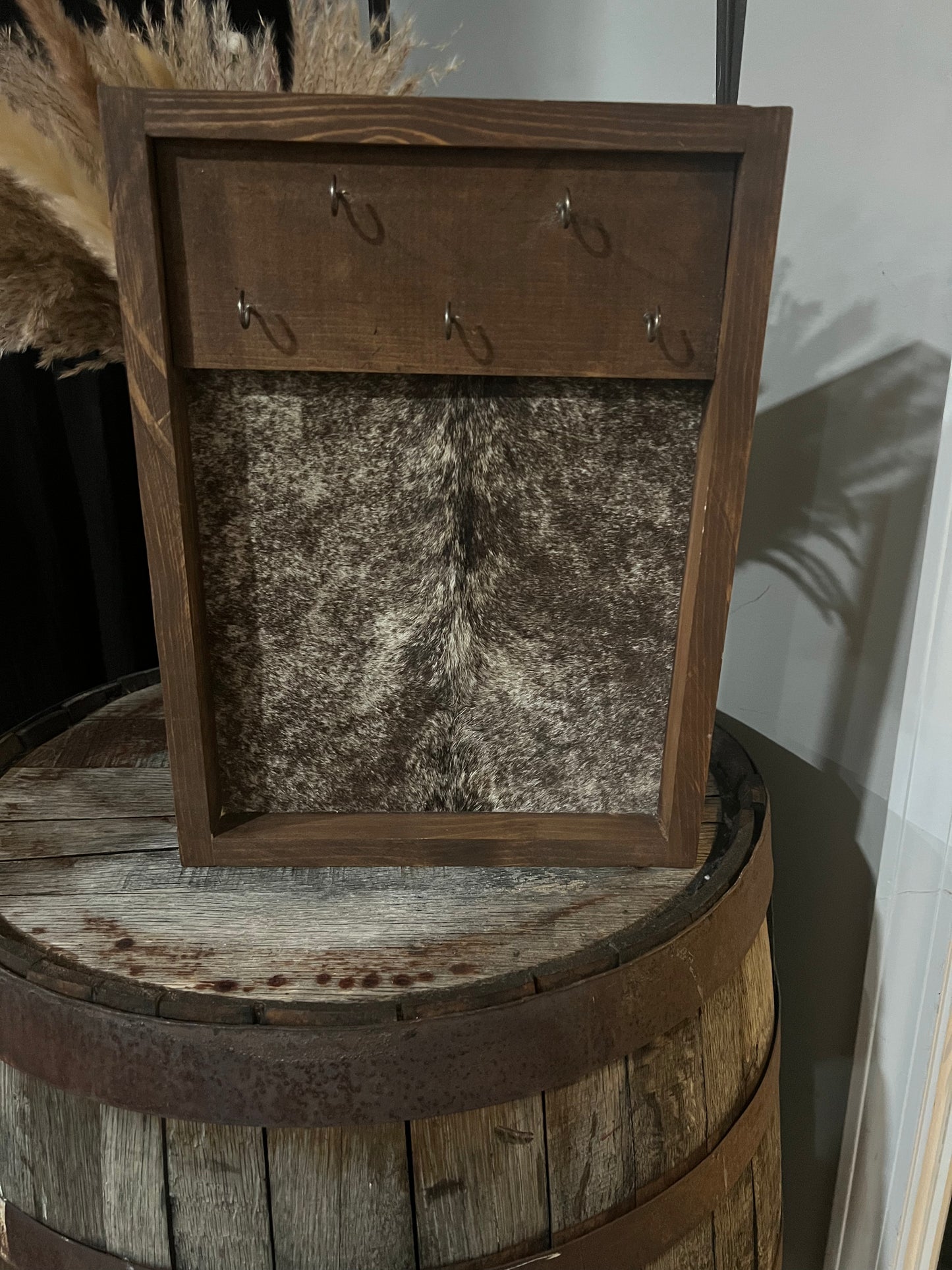 Wooden frame with hooks on a rustic wooden barrel