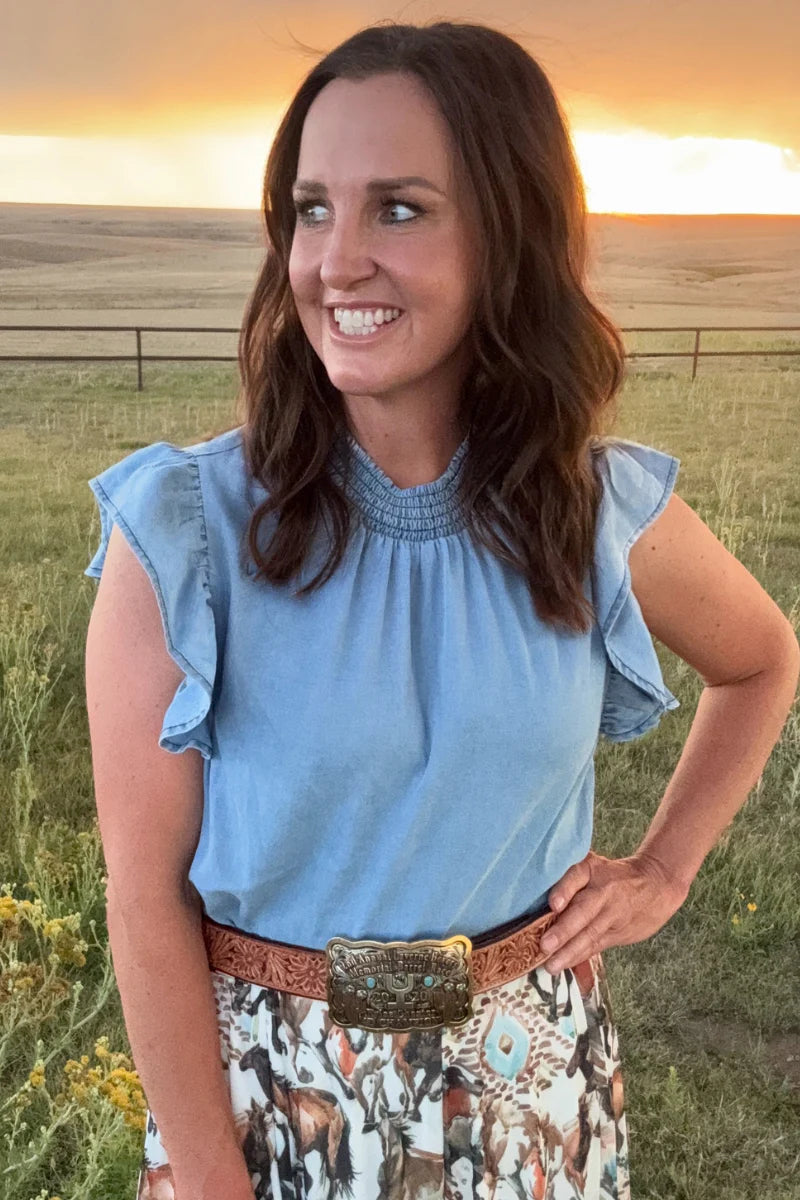 Woman standing in a field with a sunset in the background