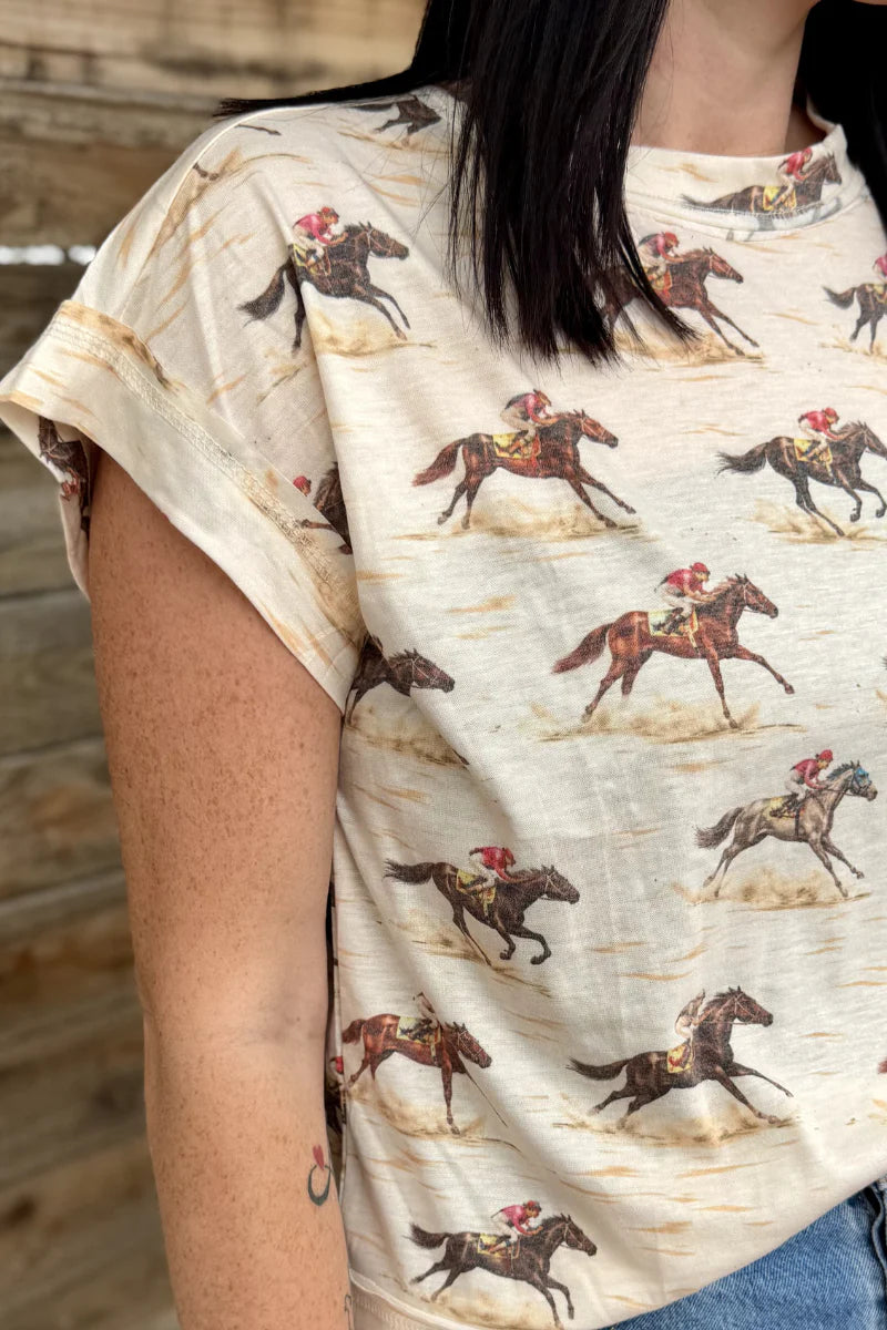 Person wearing a t-shirt with horse and jockey print against a wooden background